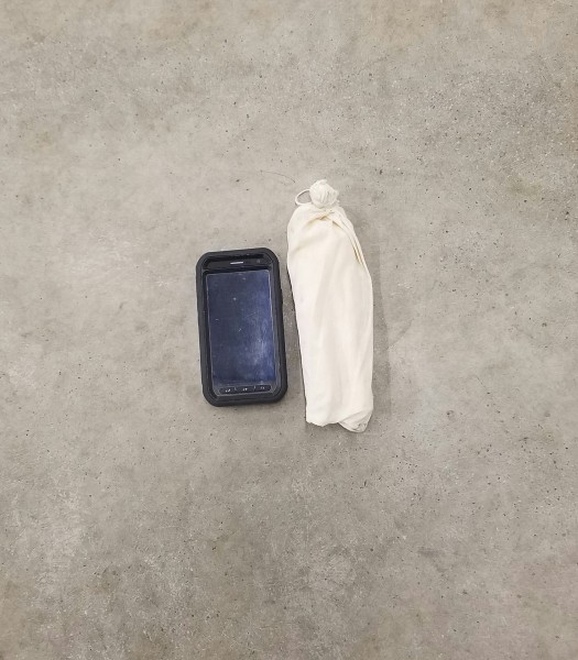 A submitted photo of the item reported missing. The cell phone in the photo is for a size reference only; there was no cell phone with the substance In the cotton bag.