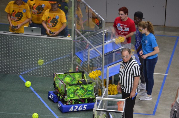 Jessie Pitz, in blue, feeds gears to Luna in the third round of semifinals at the Smoky Mountain Regional in Knoxville on Saturday, March 25, 2017. The Secret City Wildbots, Team 4265 of Oak Ridge, competed in the Smoky Mountain Regional this week. (Photo by Angi Agle)