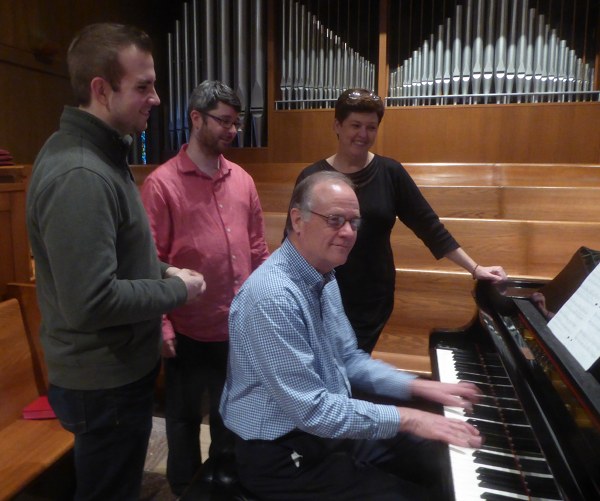 Choir directors Seth O’Kegley (FUMC) and Anna Thomas (FPC), as well as organist Simon Hogg (SSEC) chat while composer John Purifoy plays piano. (Submitted photo)