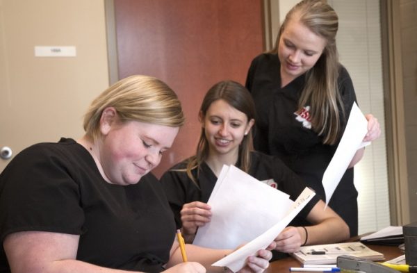 Roane State Massage Therapy Club members, from left, Mary Lewis, Brooke Lee, and Ciarra Wallace process the requisite paperwork for people seeking massages during the club’s Friday afternoon fundraising program. (Photo by Roane State)