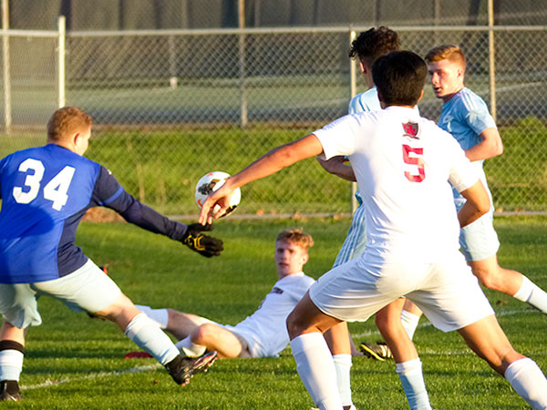 Despite falling, Austin Vinyard (9) of Oak Ridge (in center background) is able to cross the ball past Gibbs goalkeeper Dean Boone (34) to Masa Kato (5) for a goal at the left side of the net during a 5-0 win for the Wildcats at the Oak Ridge Soccer Complex on Tuesday, April 4, 2017. (Photo by John Huotari/Oak Ridge Today)