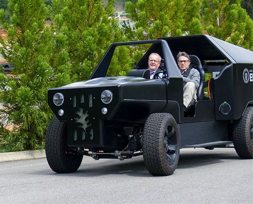 Energy Secretary Rick Perry drives a 3D printed personal utility vehicle at Oak Ridge National Laboratory's Manufacturing Demonstration Facility on Hardin Valley Road on Monday, May 22, 2017. His passenger is Craig Blue, director of energy efficiency and renewable energy programs at ORNL. (Photo by John Huotari/Oak Ridge Today)