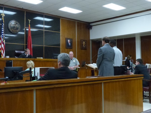 Cassen Jackson-Garrison, a former police officer and professional football player, has agreed to plead guilty to statutory rape and official misconduct, and he will be sentenced to two years of supervised probation, officials said this week. Jackson-Garrison is pictured above standing at right during a plea agreement hearing in Anderson County Criminal Court on Monday, June 12, 2017. (Photo by John Huotari/Oak Ridge Today)