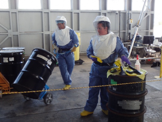 Personnel from Y-12 National Security Complex and Oak Ridge National Laboratory participate in simulated radiation contamination and perform large drum packaging operations. (Photo by NNSA)