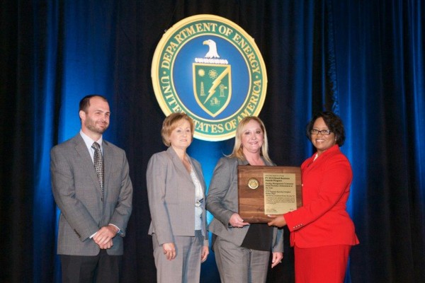 From left to right, Ryan Johnston and Lisa Copeland, Consolidated Nuclear Security LLC Small Business program managers, and Cindy Morgan, senior supply chain manager, receive an award for Facility Management Contractor Small Business Achievement of the Year from Christy Jackiewicz, Acting Director of the U.S. Department of Energy’s Office of Small and Disadvantaged Business Utilization. (Photo by CNS)