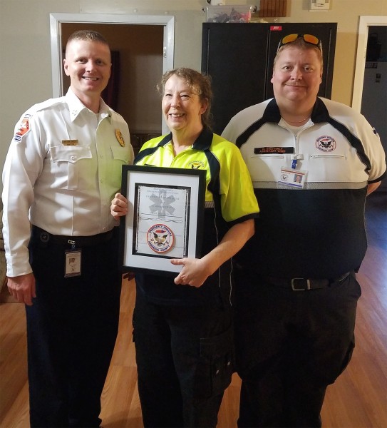 Anderson County EMS Director Nathan Sweet, left, presents Millie Huddleston, a Roane State paramedic program graduate, an award naming her the EMS's "Paramedic of the Year." Also pictured is Darek Shetterly, the organization's assistant director. (Photo by Roane State Community College)