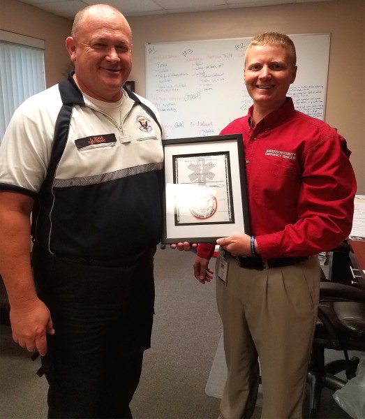 Anderson County EMS Director Nathan Sweet, right, presents Lt. Steve Seals, a graduate of Roane State's paramedic program, with an award naming him the EMS's "Officer of the Year." Sweet is also a Roane State paramedic program graduate. (Photo by Roane State)