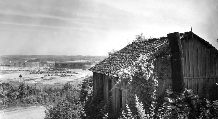 Pictured above is early construction in 1942 on the K-25 plant with one of the original homes in the city that became Oak Ridge. (Photo by Ed Westcott courtesy U.S. Department of Energy's Oak Ridge Office)