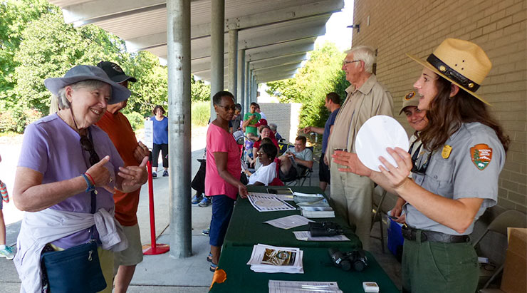 The National Park Service started distributing free eclipse glasses and free eclipse viewers at the American Museum of Science and Energy in Oak Ridge during the total solar eclipse on Monday, August 21. At right is Kendra Ownby, cultural resources program manager for the Manhattan Project National Historical Park, Big South Fork River and Recreational Area, and Obed Wild and Scenic River. (Photo by John Huotari/Oak Ridge Today)