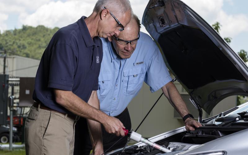 Nance Ericson, left, and Bruce Warmack of Oak Ridge National Laboratory test the DC Hot Stick on a hybrid electric vehicle. (Photo: Carlos Jones, ORNL)