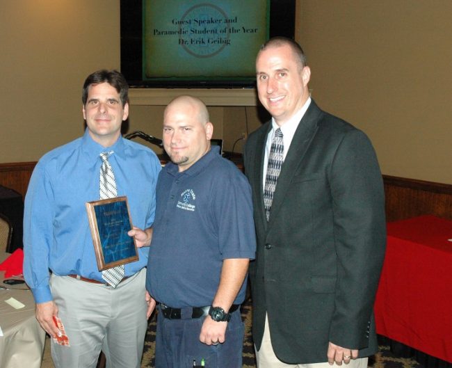 Roane State Paramedic Student of the Year Russell Collins (center) is congratulated by Dr. Erik Geibig with TeamHealth Emergency Medicine (left) and Roane State paramedic program director David Blevins. (Photo by Roane State Community College)