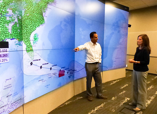 Jibonananda "Jibo" Sanyal, left, and Amy Rose of Oak Ridge National Laboratory discuss the lab's help with data on electric power outages and population counts in hazards and emergencies such as Hurricane Harvey in Texas and Hurricane Irma, approaching from the Atlantic Ocean above, as pictured on Tuesday, Sept. 5, 2017. (Photo by John Huotari/Oak Ridge Today)