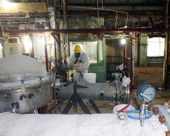 A worker removes asbestos from Building 7500, a former research reactor at Oak Ridge National Laboratory. (Photo courtesy DOE Office of Environmental Management)