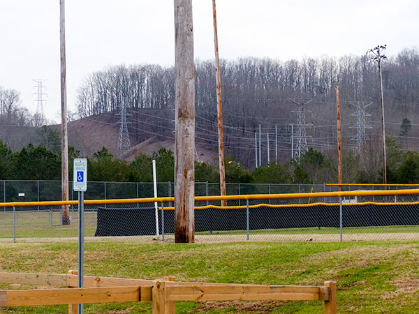 This picture from the Oak Ridge Baseball Complex on Wilberforce Avenue shows the power lines that come over Pine Ridge from the Y-12 National Security Complex and run between the baseball complex and the Scarboro neighborhood. The H towers that could be erected on Pine Ridge for a new electrical substation at Y-12 are reported to be about as tall as a baseball field light pole. (Photo by John Huotari/Oak Ridge Today)