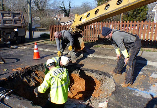 The Oak Ridge Public Works Department crew pictured above repairing a broken six-inch water line under Northwestern Avenue on Saturday, Jan. 6, 2018, is, from left, Joey Wheeler, equipment operator, standing on pavement, and Michael Brown, utility line maintenance crew chief; and in hole, Gene Wilson, water specialist; and Jeremy Justice, maintenance mechanic. (Photo by John Huotari/Oak Ridge Today)