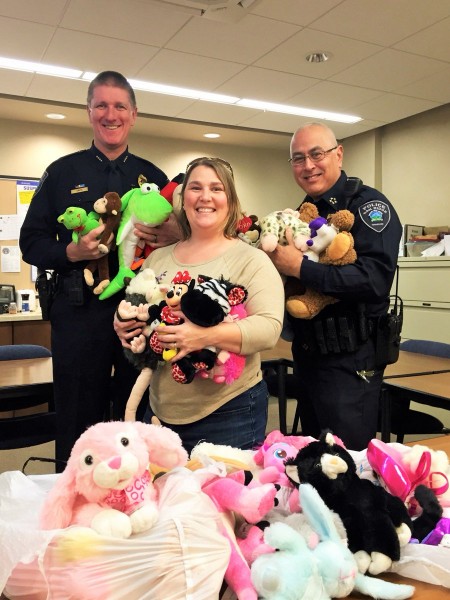 Cynthia Barreira brought dozens of stuffed animals contributed by her 10-year-old daughter to the Oak Ridge Police Department for staff to pass out to children during stressful incidents. Also pictured above are ORPD Chief Jim Akagi, right, and Deputy Chief Robin Smith. (Photo by ORPD)