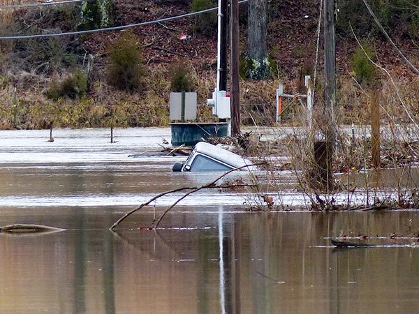 A man escaped from a vehicle in flood water on Airport Road on the east side of Oliver Springs on Saturday night, Feb. 10, 2018, authorities said. The vehicle, reported to be a Jeep, was submerged under flood water at one time, but its top was visible early Sunday afternoon. (Photo by John Huotari/Oak Ridge Today)