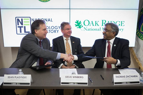 U.S. Department of Energy Assistant Secretary for Fossil Energy Steve Winberg looks on as Acting National Energy Technology Laboratory Director Sean Plasynski, left, and Oak Ridge National Laboratory Director Thomas Zacharia shake hands after signing a research agreement on new ways to use coal on Friday, March 2, 2018. (Photo courtesy NETL)