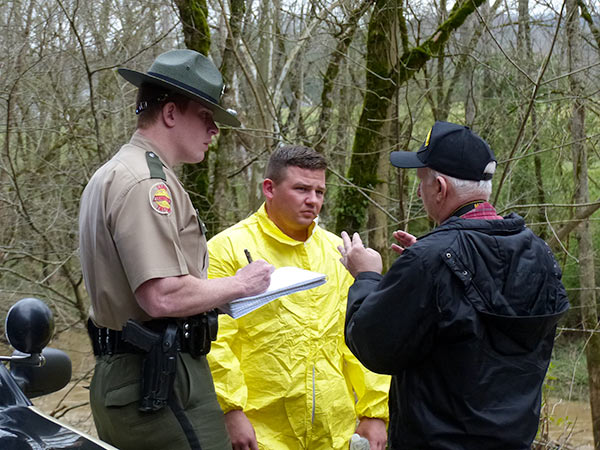 Pictured above investigating a fatal single-vehicle crash in Poplar Creek along Poplar Creek Road in Roane County late Tuesday morning, March 20, 2018, are, from left, Tennessee Highway Patrol Trooper James Capps, Trooper Nathaniel Crow, and Roane County Medical Examiner Thomas Boduch. (Photo by John Huotari/Oak Ridge Today)