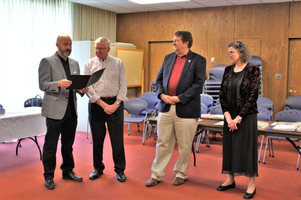 Oak Ridge City Council members Jim Dodson, left, and Kelly Callison, second from left, read a proclamation for Kathy McNeilly, right, during her retirement celebration at Oak Ridge Public Library on Friday, June 15, 2018. Also pictured is Oak Ridge City Manager Mark Watson. (Photo by City of Oak Ridge)
