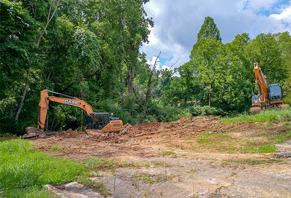 After a years-long dispute over alleged code violations, the 13 Applewood Apartments buildings on Hillside Road and Hunter Circle have been demolished. A Brady Excavating and Demolition crew removes the last basement on West Hunter Circle on Monday, July 9, 2018. (Photo by John Huotari/Oak Ridge Today)