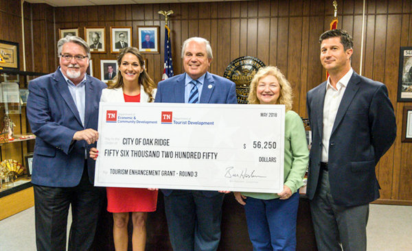 Pictured above during a state grant announcement at the Oak Ridge Municipal Building for national park signs and waterfront improvements on Tuesday, July 31, 2018, are, from left, Dave Jones, East Tennessee division manager of Tennessee Tourist Development; Amy New, assistant commissioner of community and rural development for the Tennessee Department of Economic and Community Development; Oak Ridge Mayor Warren Gooch; Jody Sliger, community development director for the Tennessee Department of Economic and Community Development; and Marc DeRose, president of Explore Oak Ridge. (Photo by John Huotari/Oak Ridge Today)