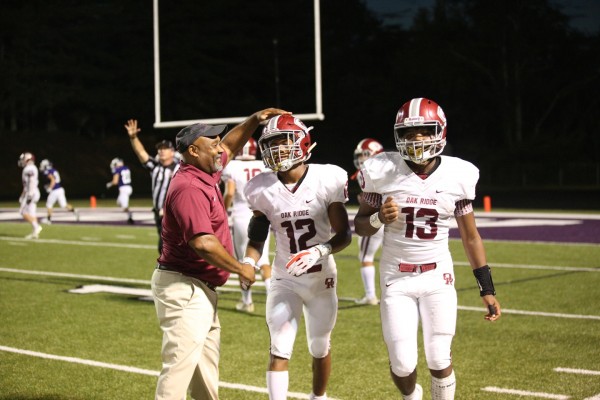Oak Ridge assistant coach John Spratling, left, celebrates with seniors Kai'Reese Pendergrass (12) and Herbert Booker (13) during a 41-13 win at Sevier County on Friday, Sept. 21, 2018. (Photo by Luther Simmons)