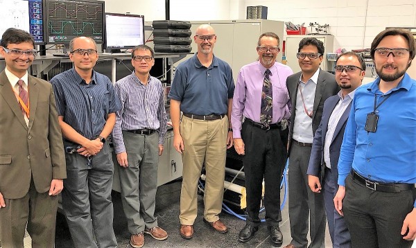 Researchers demonstrated a 120-kilowatt wireless power transfer at the National Transportation Research Center, a U.S. Department of Energy Office of Science User facility at Oak Ridge National Laboratory. From left to right above are ORNLâ€™s Saeed Anwar, Burak Ozpineci, Gui-Jia Su, and David Smith; DOE Vehicle Technology Programâ€™s Lee Slezak; and ORNLâ€™s Veda Galigekere, Omer Onar, and Jason Pries. (Photo courtesy ORNL)