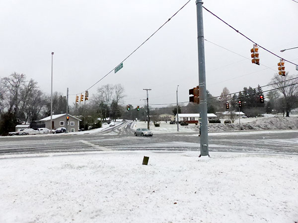 Many roads in Oak Ridge were covered by a wet, slushy snow on Sunday morning, Dec. 9, 2018, and some were slippery even when they appeared relatively clear. Pictured above is North Illinois Avenue at West Outer Drive. (Photo by John Huotari/Oak Ridge Today)