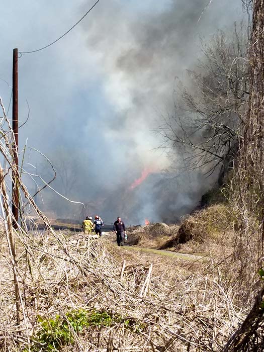 Fire crews battle a brush fire near the railroad tracks at Elza Gate in east Oak Ridge on Friday afternoon, March 22, 2019. (Photo by John Huotari/Oak Ridge Today)