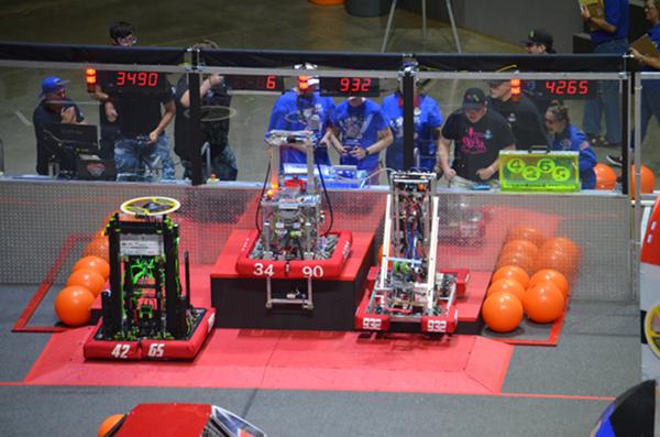 (Far right drive station, pictured from left to right) Blake Norris, Mark Buckner (mentor), and Patience Sims are pictured above in the closing seconds of match 30, which ended in a tie on Friday, March 29, 2019, during the Smoky Mountains Regionals robotics tournament. (Photo by Angi Agle)